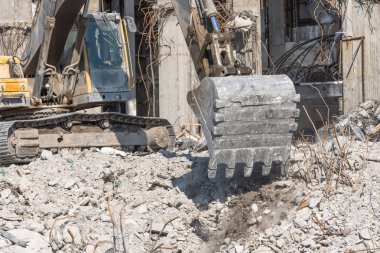 Metal kova hidrolik ekskavatör Boom taş ve yıkılmış bir binanın enkaz Digs. Yakın görünüm.