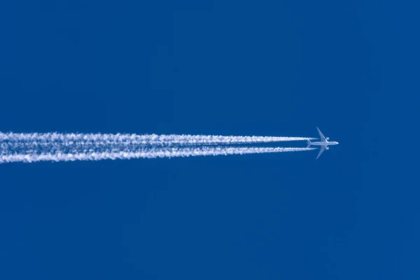 Aviones dejando rastro de la estela de izquierda a derecha en un cielo azul claro . — Foto de Stock