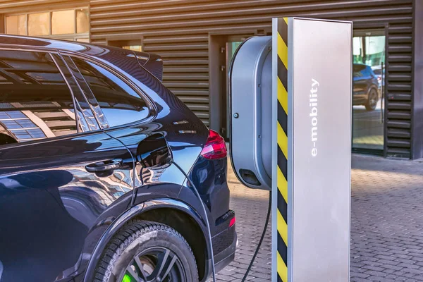 Het opladen van een elektrische auto bij een auto reparatie winkel service garage. Tanken voor elektrische auto's e-Mobility. — Stockfoto