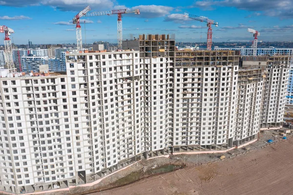 Vista aérea de la parte superior de la construcción a gran escala de un complejo residencial con vistas a la construcción de grúas. —  Fotos de Stock