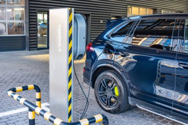 Bir araba tamir dükkanı servis garajında bir elektrikli araba şarj. Elektrikli arabalar için yakıt ikmali e-mobilite.