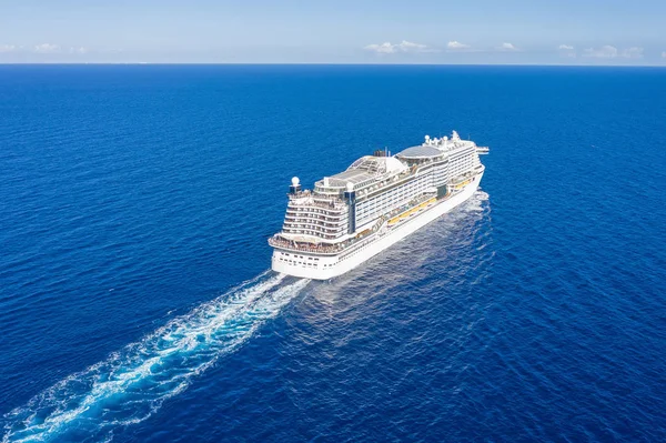Cruise ship liner goes into horizon the blue sea leaving a plume on the surface of the water seascape. Aerial view The concept of sea travel, cruises. — Stock Photo, Image