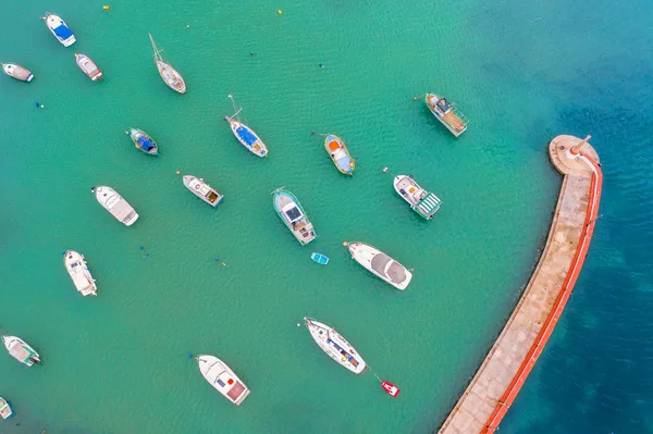 ターコイズブルーの水と桟橋と灯台を備えた多くの小さな漁船と湾の航空写真. — ストック写真