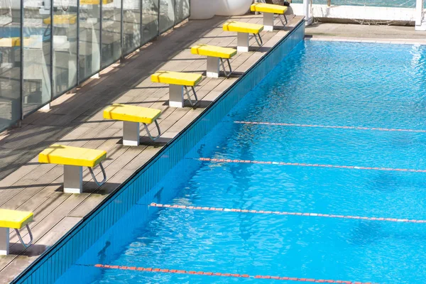 Starting blocks, jump platform in row by the swimming pool.
