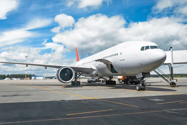 Passenger aircraft with boarding stairs, waiting for boarding passengers and baggage before the flight, summer airport trip.