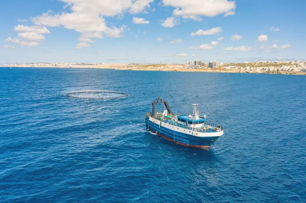 Halászhajócsónak úszó a kék tenger partja mentén. — Stock Fotó