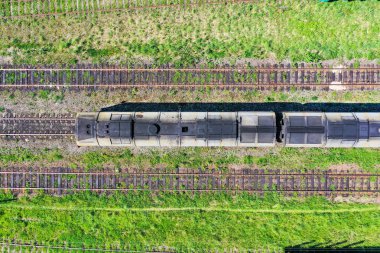 Üç demiryolu rayları ve merkezi lokomotif, üst hava görünümü.