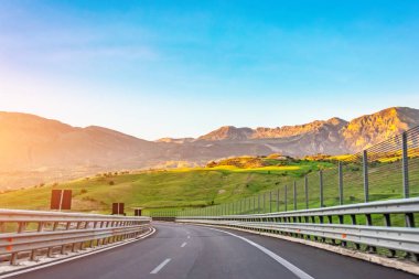 Otoban yolu üzerinde görünümü ve tepelerde açmak, gün doğumunda akşam dağlar, seyahat gezisi.