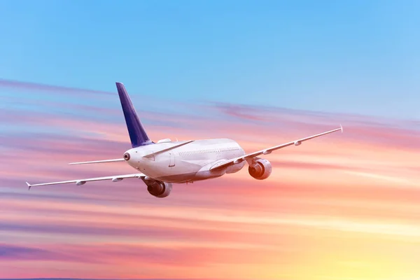 Passagiersvliegtuig neemt af tegen de achtergrond van zonsondergang en wolken. — Stockfoto