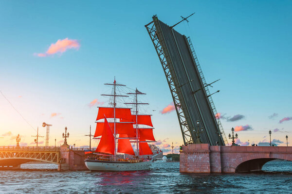 Scarlet sails in St. Petersburg on the Neva River, sunset at the divorced bridge.