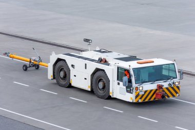 Havalimanı traktörü, havaalanının direksiyon rotası boyunca gidiyor..