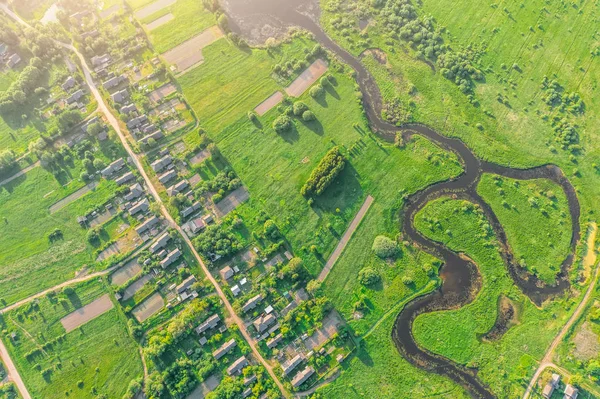 空中景观从村庄的高度与房屋和街道，犁地，草地，河在夏天. — 图库照片