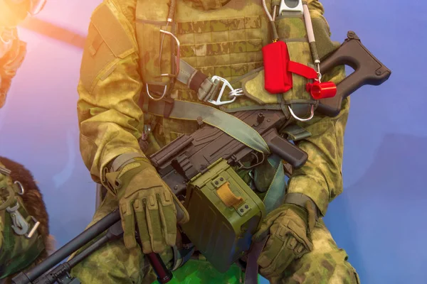 近距离观察一个穿着军装、手拿武器的坐着的士兵. — 图库照片