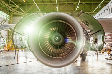 Bir flaş ışığı ile hangar içinde Havacılık bakım uçak motoru denetler.