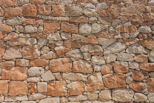 Die Wand aus ovalem Kopfsteinpflaster Farbe rot und orange, Hintergrundstruktur. — Stockfoto