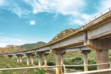 İki yol dönüş otoyol köprüsü, yeşil tepeler arasında vadide viyadük destekler, ulaşım altyapısı.