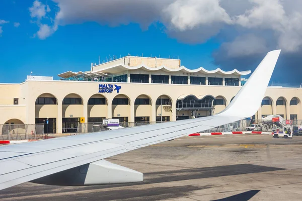 Wing view airplane to the main building of Malta International Airport Maltese Islands.. Luqa, Malta 14 Maio, 2019 . — Fotografia de Stock