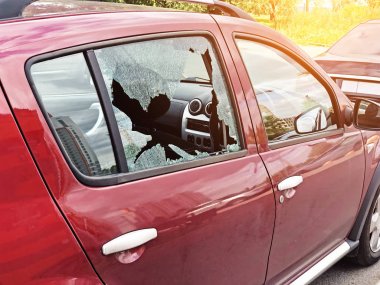 Broken glass on the passenger door of a passenger car parked. The concept of crime of car theft, theft of valuables. clipart