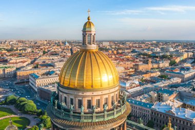 St. Isaac Katedrali'nin kubbesinin ve St. Petersburg şehrinin tarihi bölümünün ve yansıyan altın akşam güneş ışığının manzarası.