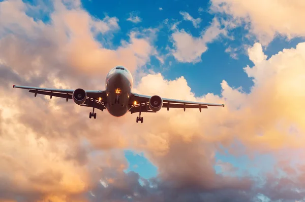 Avond hemel met gebroken mooie wolken van warme kleuren en vliegtuig naderen van de landing Airport. — Stockfoto