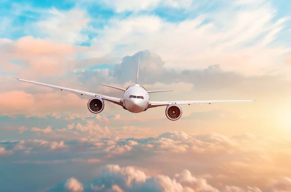 Vliegtuig vliegen boven de avondlicht boven de wolken bij zonsondergang. — Stockfoto