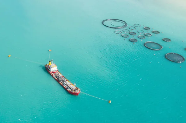 Aerial view Cargo tanker afgemeerd in de baai, in de buurt van de boerderij voor het kweken van vis. — Stockfoto