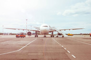 Yolcu uçağı, havaalanı terminalinden yolcuların binmesini bekliyor..