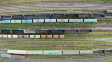 Demiryolu istasyonunda çeşitli tren vagonlarının havadan görünüşü, üst manzara.