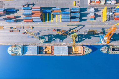 Hava üstü görünümü büyük kargo gemisi limanda iskelede demirlemiş, mal, metal, beton ve diğer katı hammadde yükleme.