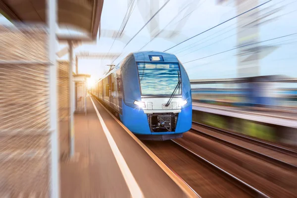 Elektrozug fährt mit hoher Geschwindigkeit am Personenbahnsteig in der Stadt vorbei. — Stockfoto