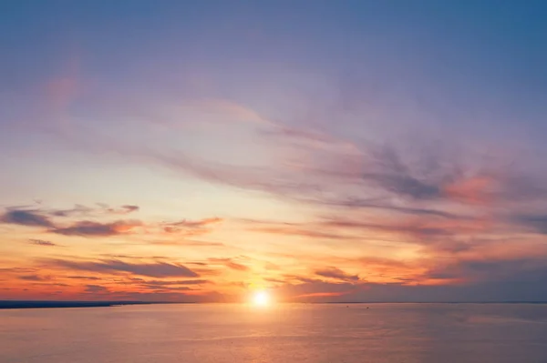 Skyline mit hellem Sonnenuntergang in warmen Farben und malerischen hohen Wolken über der Bucht, Luftaufnahme. — Stockfoto
