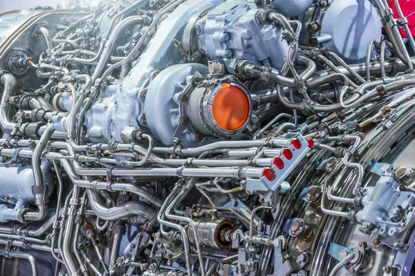 El complejo mecanismo de tubos y otros sistemas de encuadernación en un motor de avión a reacción, vista de cerca. Tema de producción industrial . — Foto de Stock