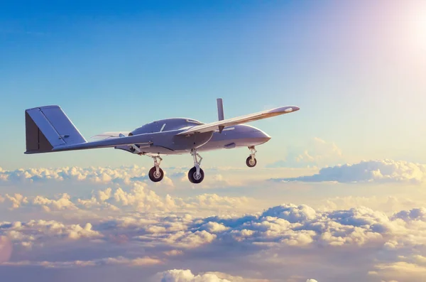 Unmanned military aircraft reconnaissance uav patrolling the evening at sunset sky clouds.