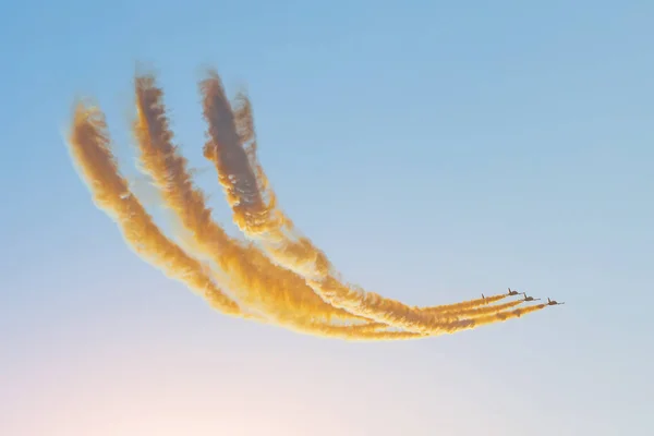Aerobatic team groep van vechters Jet vliegt in de lucht met fel gekleurde rook onder de ondergaande zon in de avond hemel — Stockfoto