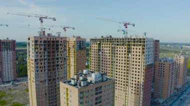 İnşaat vinçler mavi gökyüzü manzaralı bir konut kompleksi havadan üst görünümü büyük ölçekli inşaat