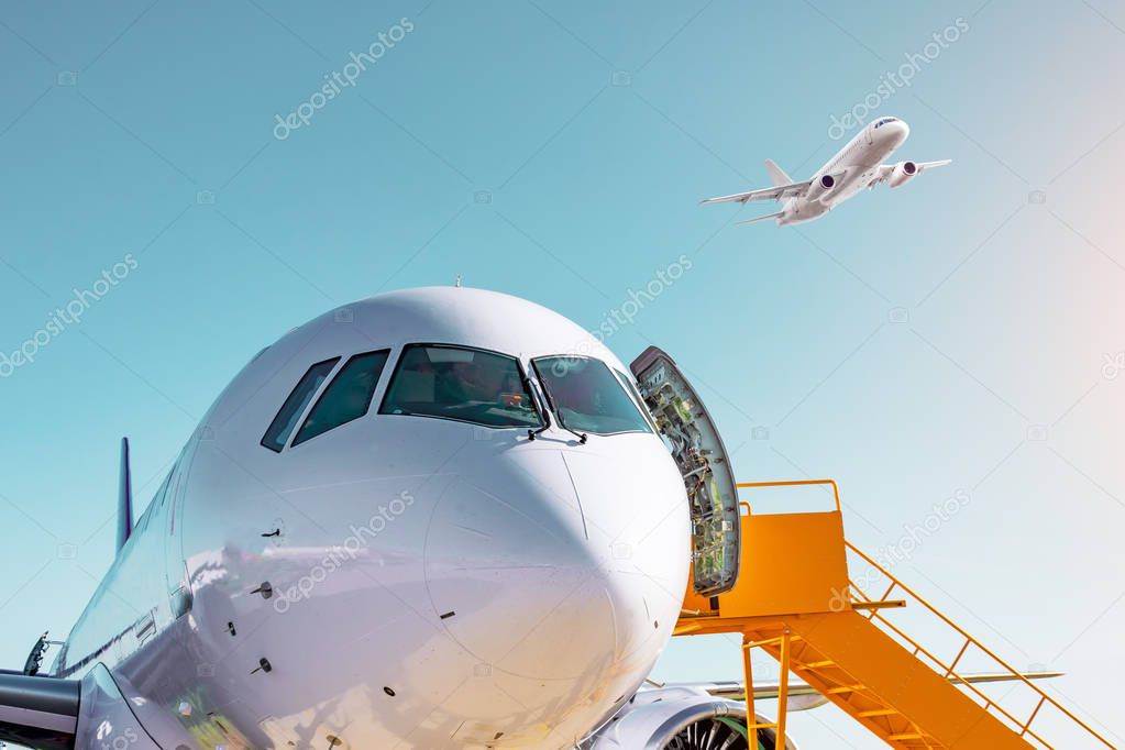 Airplane view from the front cockpit windshield fuselage and a passenger plane takes off in the sky at sunset light at the airport.