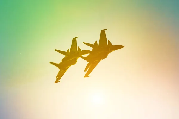 Dos aviones de combate jet avión sol resplandor cálido amarillo naranja verde gradiente cielo — Foto de Stock