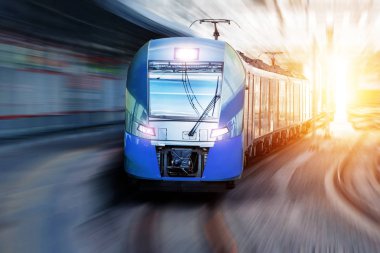 Yolcu treni şehir manzarasında istasyondan geçiyor.