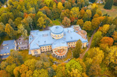 Parlak renkli ağaçlar arasında sonbahar parkında eski terk edilmiş bina, havadan görünümü.