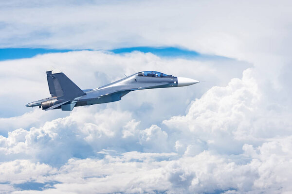 Combat fighter jet flies high in the clouds.