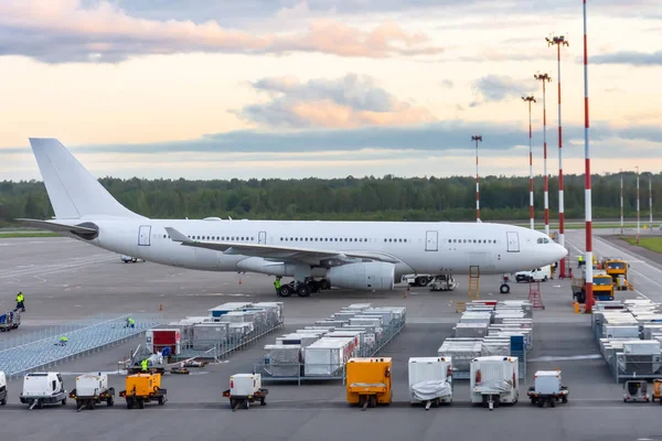 Aviones de cuerpo ancho de largo alcance estacionados en el aeropuerto, frente a él hay contenedores de alimentos y fuentes de alimentación móviles. Servicio de vuelo . — Foto de Stock