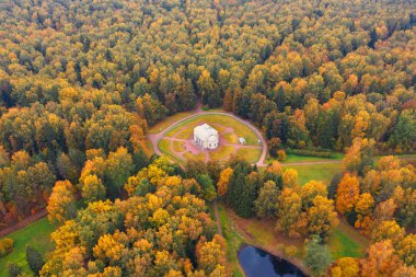 Pavlovsky Park 'taki Round Hall binasının havadan görünüşü Saint-Petersburg civarındaki sonbahar ağaçlarının arasında..