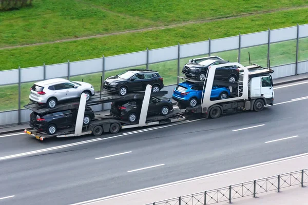 Új autók közúti szállítása pótkocsin teherautóval kereskedőknek történő szállítás céljából. — Stock Fotó