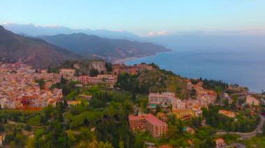 Taormina, İtalya'nın Sicilya adasında yer alan bir şehirdir. Dağların eteklerinde öfke akşam yukarıdan Havadan Görünümü