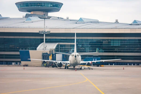 La terminal del aeropuerto y la torre atc de controladores, avión cercano esperando a los pasajeros de embarque . — Foto de Stock