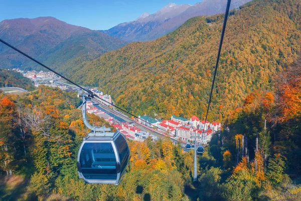 Lanová dráha s vleky a chatami pro turisty, výhled na město a podzimní les v horách Kavkazu. — Stock fotografie