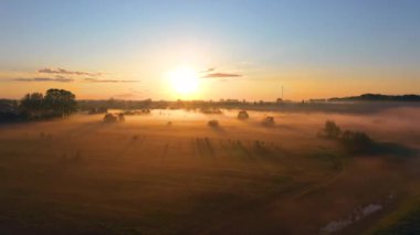 Nehrin çayırlarında sabah sisi güneş doğarken kırsal alanda, hava manzarası hızlandırılmış manzara ufku, uçan kuşlarla dolu orman köyü.