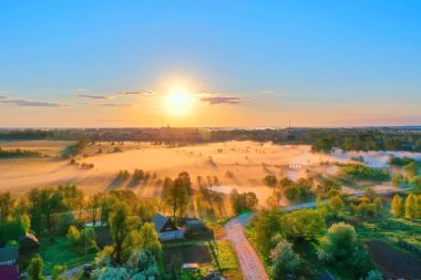 Ufkun üstündeki hava manzaralı manzara güneşi, uçan kuşlarla dolu orman köyü. Nehrin ağzındaki çayırlarda güneş doğarken sabah sisi.
