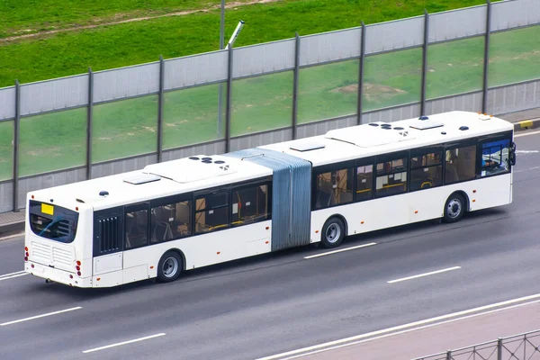 Double articulated bus rides on the highway in the city