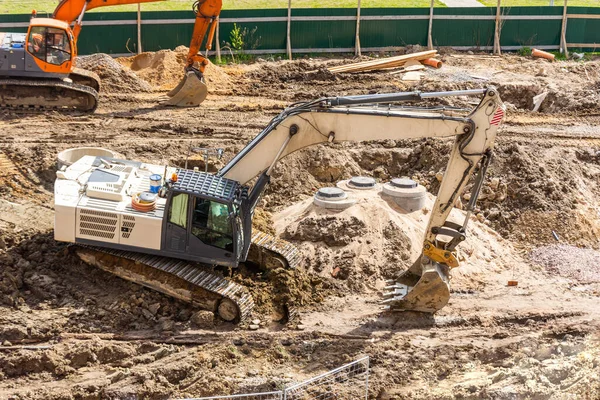 公路上的挖掘机在新的土路上挖了土 在住宅区建造路基 — 图库照片
